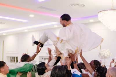 Parking vide entouré d'arbres et de bâtiments sous un ciel bleu avec quelques nuages.