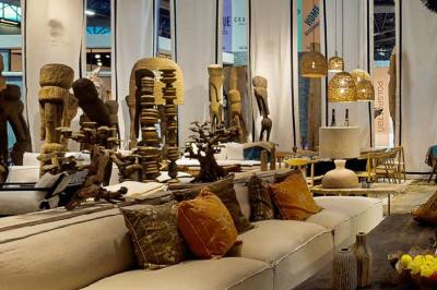 Sculpture de lion en pierre, table en bois sombre avec chandeliers noirs, vase bleu et décor rustique en arrière-plan.