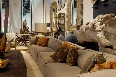 Sculpture de lion en pierre, table en bois sombre avec chandeliers noirs, vase bleu et décor rustique en arrière-plan.