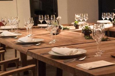 Sculpture de lion en pierre, table en bois sombre avec chandeliers noirs, vase bleu et décor rustique en arrière-plan.