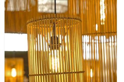 Tables en bois dressées avec des assiettes, des verres et des serviettes blanches dans une salle élégante.