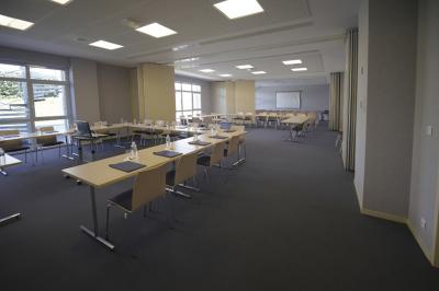 Espace intérieur lumineux avec des fauteuils en rotin, une table en bois et une décoration murale colorée.