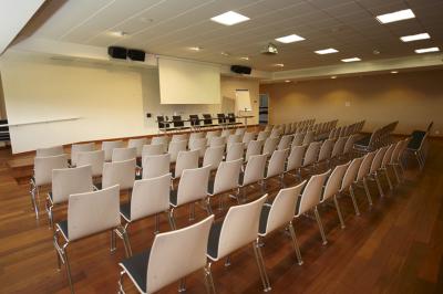 Espace intérieur lumineux avec des fauteuils en rotin, une table en bois et une décoration murale colorée.