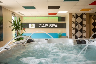 Espace intérieur lumineux avec des fauteuils en rotin, une table en bois et une décoration murale colorée.