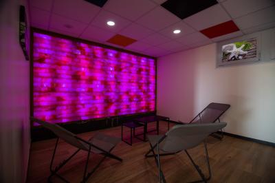 Chambre d'hôtel moderne avec lit double, bureau, téléviseur mural, portant, et décoration murale à motifs floraux.