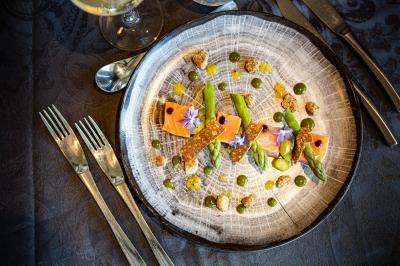 Chambre d'hôtel moderne avec lit double, bureau, téléviseur mural, portant, et décoration murale à motifs floraux.