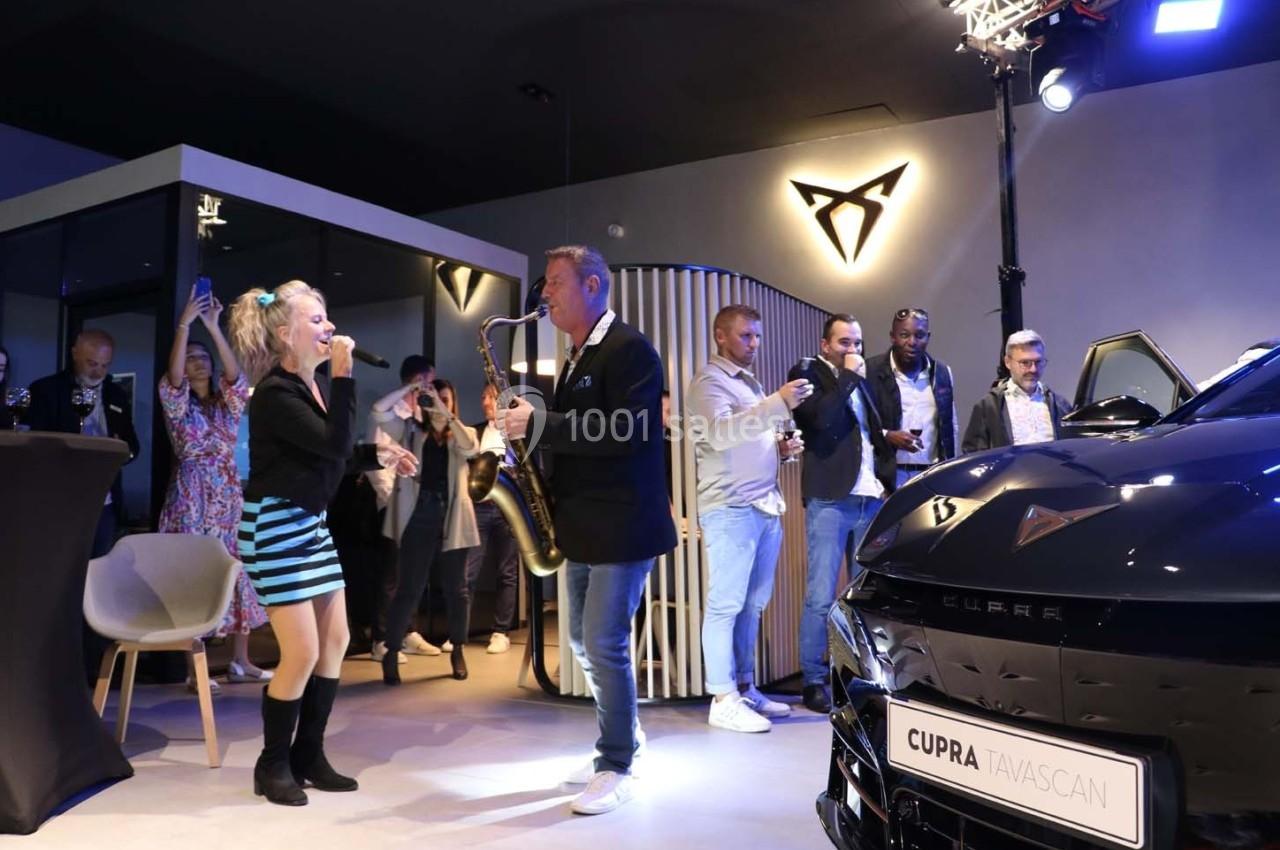 Une chanteuse et un saxophoniste se produisent lors d'un événement dans un showroom automobile Cupra.