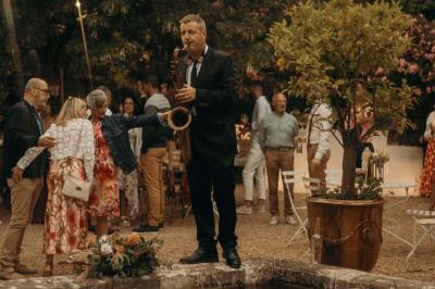 Deux personnes chantent et jouent de la musique en direct dans une ambiance nocturne éclairée par des lumières.