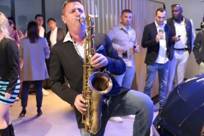 Deux personnes chantent et jouent de la musique en direct dans une ambiance nocturne éclairée par des lumières.
