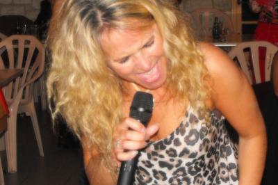 Deux personnes chantent et jouent de la musique en direct dans une ambiance nocturne éclairée par des lumières.