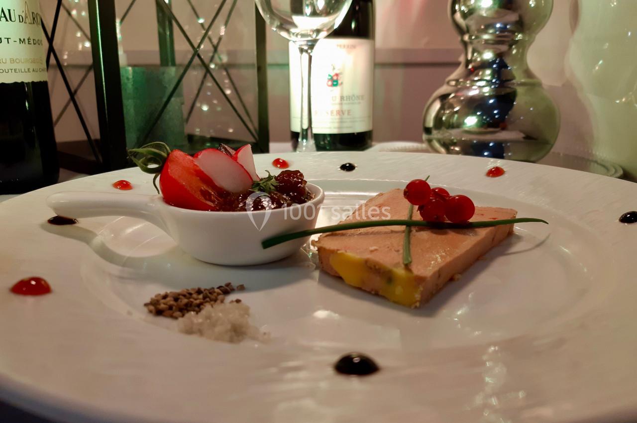 Assiette gastronomique avec foie gras, confiture, radis, groseilles, ciboulette et condiments, servie dans un décor élégant.