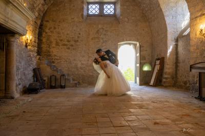 Femme assise, vêtue d'une robe blanche fluide, posant avec une expression sereine sur fond neutre.