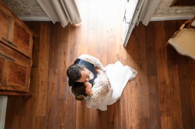 Femme assise, vêtue d'une robe blanche fluide, posant avec une expression sereine sur fond neutre.