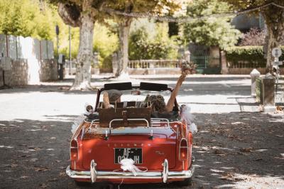 Femme assise, vêtue d'une robe blanche fluide, posant avec une expression sereine sur fond neutre.