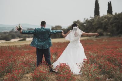 Femme assise, vêtue d'une robe blanche fluide, posant avec une expression sereine sur fond neutre.