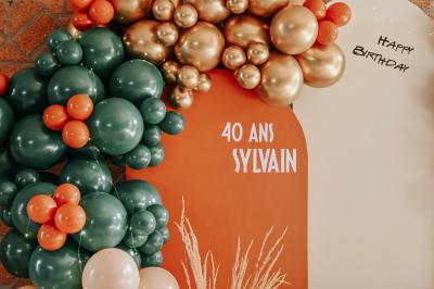 Table décorée avec des bougies torsadées, fleurs séchées et chemin de table rouge dans un cadre chaleureux.