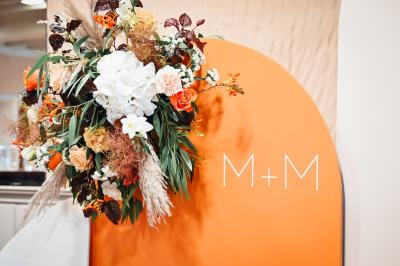 Table décorée avec des bougies torsadées, fleurs séchées et chemin de table rouge dans un cadre chaleureux.