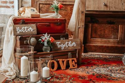 Table décorée avec des bougies torsadées, fleurs séchées et chemin de table rouge dans un cadre chaleureux.