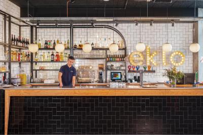 Chambre avec lit double, lits superposés en bois, éclairage chaleureux et mur décoré d'une fresque de paysage naturel.