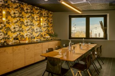 Chambre avec lit double, lits superposés en bois, éclairage chaleureux et mur décoré d'une fresque de paysage naturel.