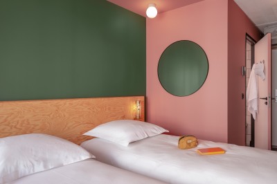 Salle de bain moderne avec douche vitrée, carrelage blanc, lavabo suspendu et éclairage mural.