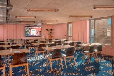Salle de bain moderne avec douche vitrée, carrelage blanc, lavabo suspendu et éclairage mural.