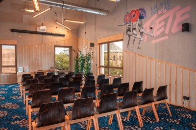 Salle de bain moderne avec douche vitrée, carrelage blanc, lavabo suspendu et éclairage mural.