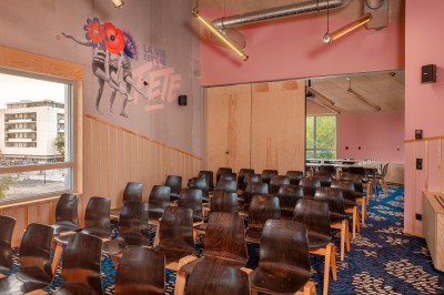 Salle de bain moderne avec douche vitrée, carrelage blanc, lavabo suspendu et éclairage mural.