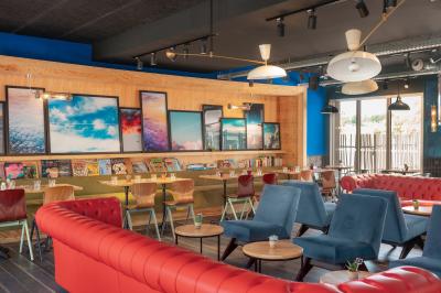 Chambre moderne avec lits superposés en bois, table ronde, chaise, et porte donnant sur l'extérieur.