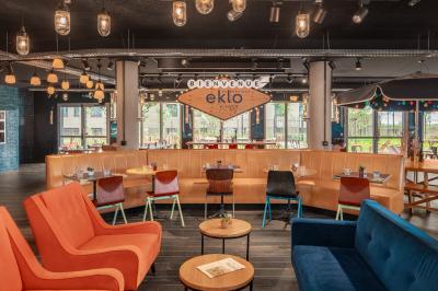 Chambre moderne avec lits superposés en bois, table ronde, chaise, et porte donnant sur l'extérieur.