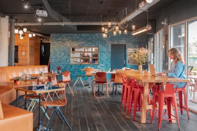 Chambre moderne avec lits superposés en bois, table ronde, chaise, et porte donnant sur l'extérieur.