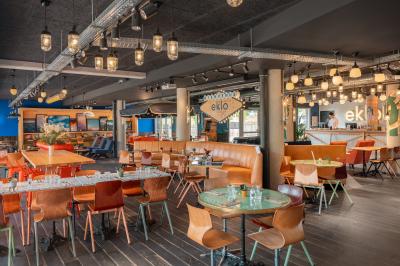 Chambre moderne avec lits superposés en bois, table ronde, chaise, et porte donnant sur l'extérieur.