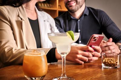 Distributeur de boisson citronnée sur pied, avec plateau de charcuterie et verre garni de menthe au premier plan.