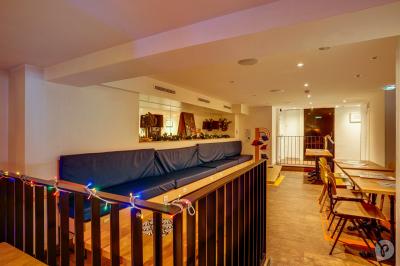 Distributeur de boisson citronnée sur pied, avec plateau de charcuterie et verre garni de menthe au premier plan.