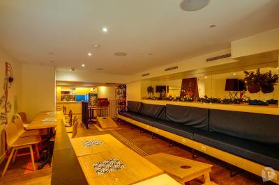 Distributeur de boisson citronnée sur pied, avec plateau de charcuterie et verre garni de menthe au premier plan.