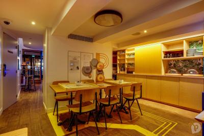 Distributeur de boisson citronnée sur pied, avec plateau de charcuterie et verre garni de menthe au premier plan.