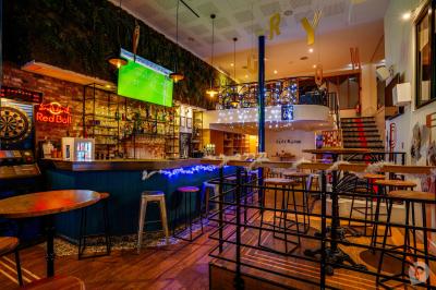 Distributeur de boisson citronnée sur pied, avec plateau de charcuterie et verre garni de menthe au premier plan.