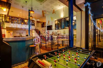 Distributeur de boisson citronnée sur pied, avec plateau de charcuterie et verre garni de menthe au premier plan.