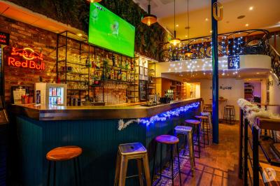 Distributeur de boisson citronnée sur pied, avec plateau de charcuterie et verre garni de menthe au premier plan.