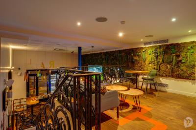 Distributeur de boisson citronnée sur pied, avec plateau de charcuterie et verre garni de menthe au premier plan.