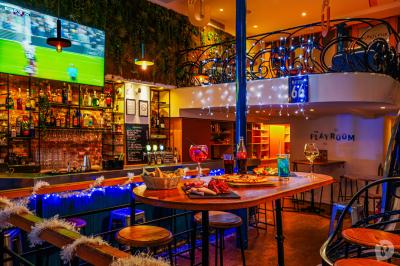 Distributeur de boisson citronnée sur pied, avec plateau de charcuterie et verre garni de menthe au premier plan.