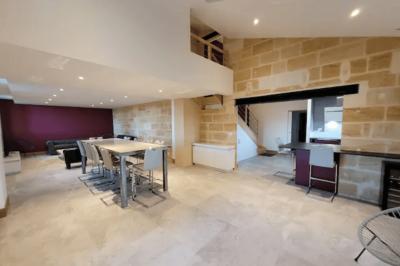 Lit avec tête de lit en métal blanc, draps et oreillers blancs, lampe de chevet sur une table contre un mur vert.