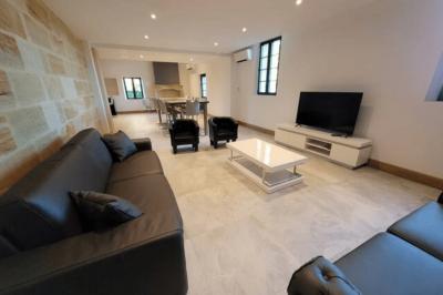 Lit avec tête de lit en métal blanc, draps et oreillers blancs, lampe de chevet sur une table contre un mur vert.