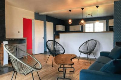 Lit avec tête de lit en métal blanc, draps et oreillers blancs, lampe de chevet sur une table contre un mur vert.