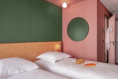 Salle de bain moderne avec douche à l'italienne, carrelage blanc, lavabo suspendu et éclairage mural.