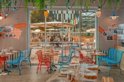 Salle de bain moderne avec douche à l'italienne, carrelage blanc, lavabo suspendu et éclairage mural.