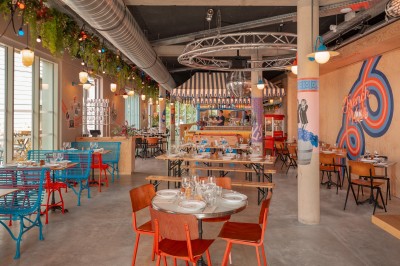 Salle de bain moderne avec douche à l'italienne, carrelage blanc, lavabo suspendu et éclairage mural.