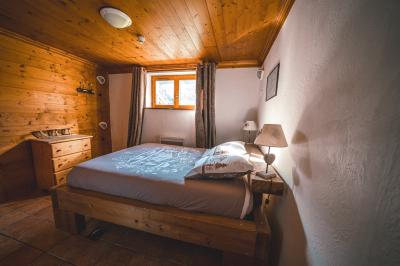 Chalets en bois entourés de neige au pied de montagnes sous un ciel bleu clair.