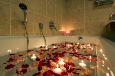 Salon avec canapé et chaises en velours rouge, table basse en bois, lampe sur pied et tableau au mur.