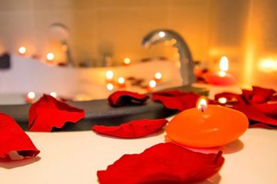 Salon avec canapé et chaises en velours rouge, table basse en bois, lampe sur pied et tableau au mur.